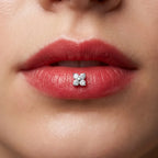 Silver titanium Ashley clover piercing worn in the center of the lower lip
