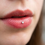 Discreet silver titanium Ashley disc worn in the center of the lower lip
