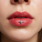 Silver titanium Ashley star piercing worn in the center of the lower lip
