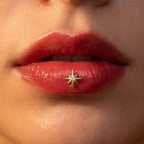 Gold titanium Ashley celestial star piercing worn in the center of the lower lip
