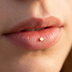 Discreet gold titanium Ashley disc worn in the center of the lower lip
