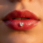 Gold titanium Ashley heart piercing worn in the center of the lower lip
