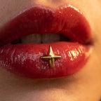 Gold titanium Ashley star piercing worn in the center of the lower lip
