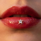 Gold titanium Ashley star cut piercing worn in the center of the lower lip
