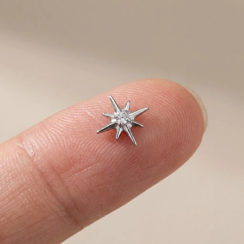 Flat back titanium Ashley celestial labret shown on a fingertip for scale
