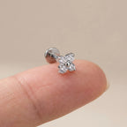 Flat back titanium Ashley clover labret shown on a fingertip for scale
