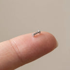 Flat back titanium Ashley disc labret shown on a fingertip for scale
