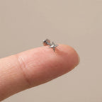 Flat back titanium Ashley star labret shown on a fingertip for scale
