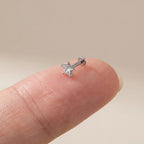 Flat back titanium Ashley star cut labret shown on a fingertip for scale
