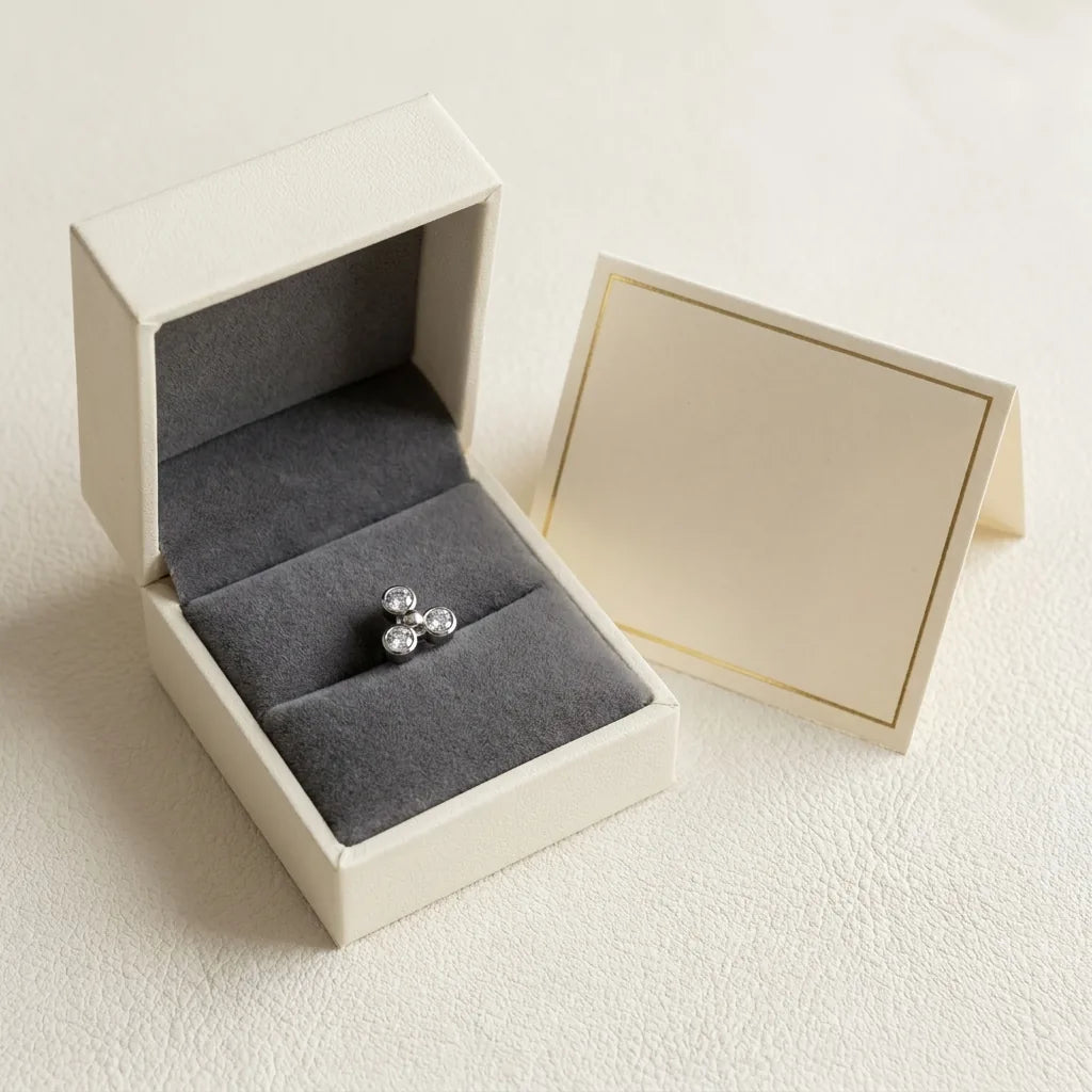 Ashley trinity piercing gift packaging with a titanium stud and a certificate card
